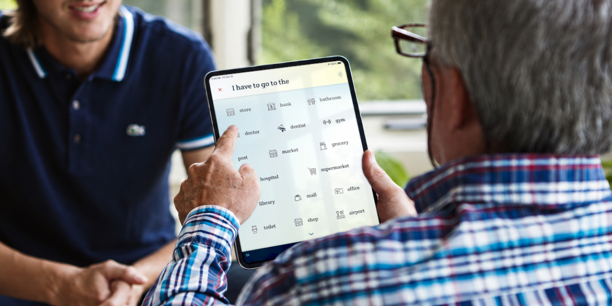An elderly man taps on Spoken's predictions to converse with his grandson.