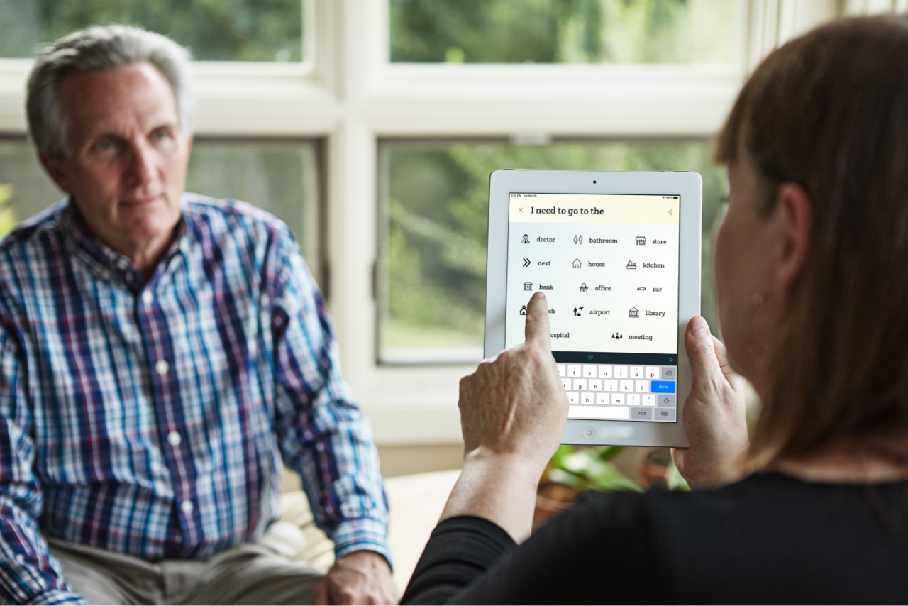 An older woman faces a man while using the Spoken app.